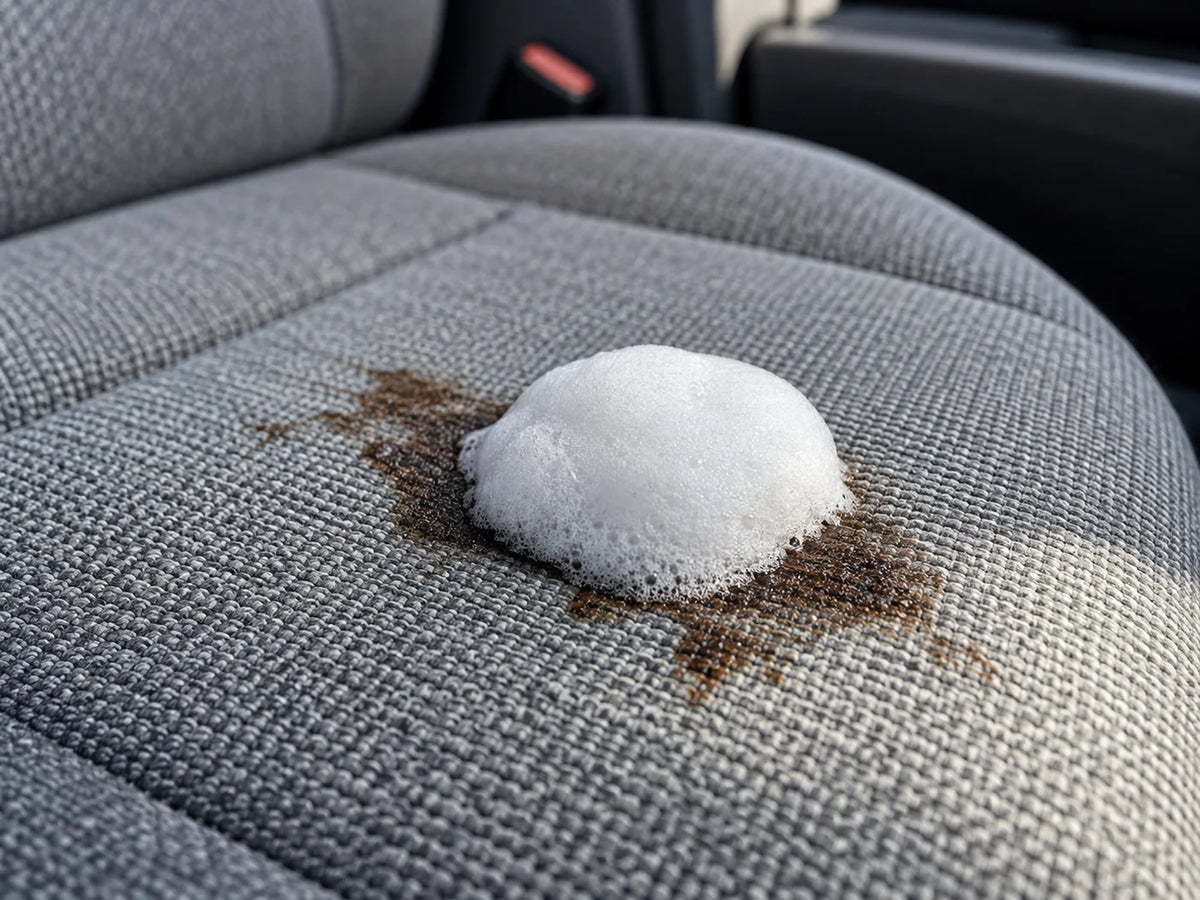 Illustrative dense white foam resting on a stained fabric car seat